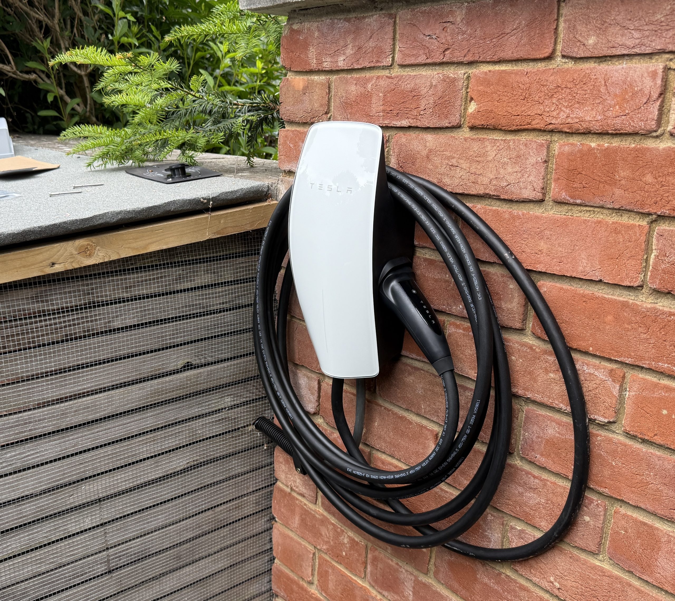 Wall Connector Tesla installé sur un mur en brique