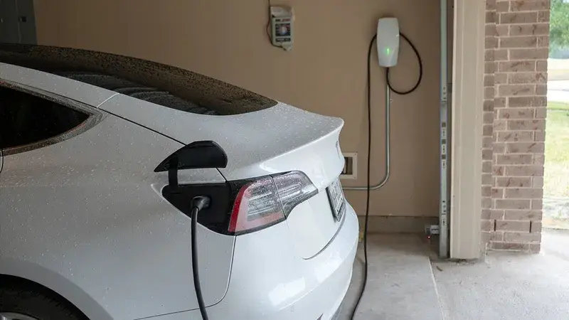 Tesla blanche en charge dans un garage résidentiel